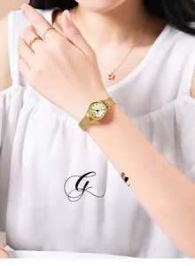 Close-up of gold mesh strap ladies watch with Roman numeral dial on model's wrist
