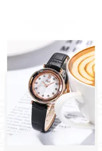 Detail of Gedi rose gold watch with black leather strap next to a white coffee cup
