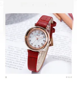 Detail of Gedi vintage watch with red leather strap and pearl dial next to pencils