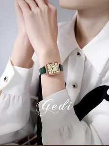 Nahaufnahme der Retro-Quarzuhr mit quadratischem Roségold-Gehäuse und grünem Lederarmband