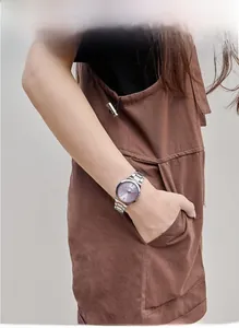 Detail of a purple sunray dial women's watch with silver steel strap on wrist