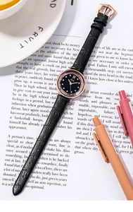 Close-up of Gedi quartz watch with black croc leather strap and rose gold dial on magazine