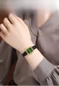Orologio vintage da donna con quadrante quadrato verde e cinturino in pelle nera sul polso