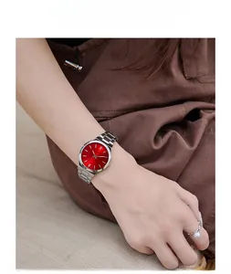 Detail of red dial ladies quartz watch with silver steel strap on a model's wrist