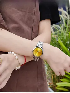 Close-up of GEDI women's watch with bright yellow dial and silver steel strap on wrist