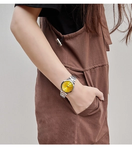 Close-up of GEDI women's watch with yellow dial and silver steel band on model wrist
