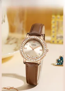 Détail du cadran de montre or rose avec cristaux mobiles et bracelet en cuir