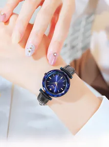 Gros plan d'une montre femme en cuir avec cadran bleu facetté sur le poignet
