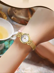 Gros plan d'une montre dorée élégante avec bracelet en maille et cadran rond minimaliste