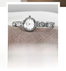 Detail of silver women's watch featuring a crystal-set X-pattern bracelet and quartz movement