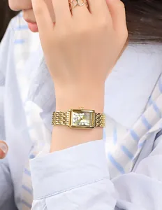 Close-up of vintage gold rectangular quartz watch with a woven link metal bracelet
