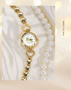 Détail d'une élégante montre bracelet dorée avec maillons en cœur et cadran cheval de bois