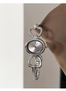 Macro shot of silver oval GEDI watch dial with sunray pattern and large link bracelet