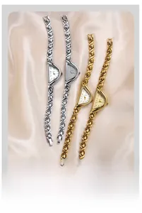 Detailed view of elegant gold and silver D-shaped quartz watches on silk background