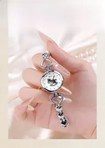 Détail d'une montre bracelet argentée à maillons cœur avec cadran cheval