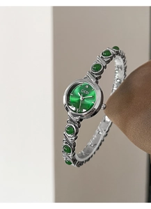 Macro detail of GEDI silver bracelet watch featuring green dial and emerald-like gemstones