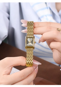 Close-up of a vintage gold rectangular watch with a metal strap on a woman's wrist