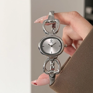 Close-up of GEDI oval silver watch with unique horse-bit bangle hollow metal strap
