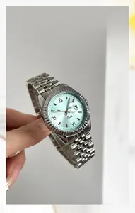 Détail d'une montre argentée avec cadran bleu clair et chiffres romains