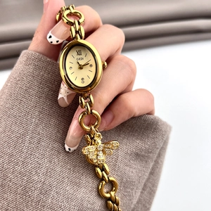 Elegant gold oval quartz watch for women with chain strap and crystal bee charm