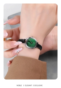 Macro detail of vintage square silver watch with sunray green dial and black leather strap