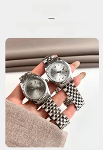 Détail d'une montre à quartz avec lunette cannelée, chiffres romains et guichet date