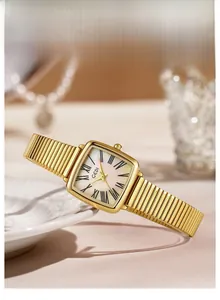 Détail d'une montre carrée dorée avec cadran en nacre et des chiffres romains noirs élégants