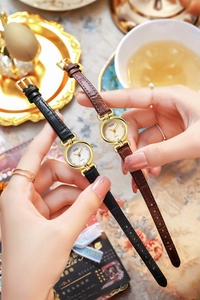 Gros plan de montres à quartz vintage avec bracelets en cuir sur fond de service à thé
