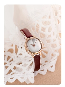 Detail of vintage ladies watch with gold tonneau case and burgundy crocodile leather strap