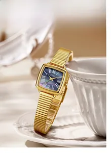 Détail d'une montre carrée dorée de luxe avec cadran en nacre violette et chiffres romains