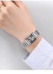 Silver rectangular watch with multi-row chain bracelet on model wrist