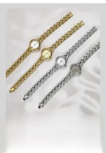 Detailed view of quartet wheat spike band quartz watches on white silk background