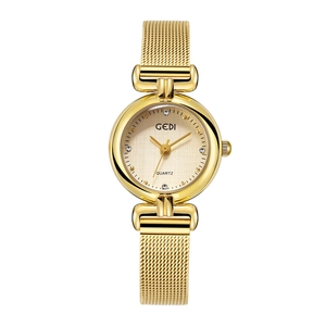 Détail d'une montre à quartz dorée avec index en strass et bracelet maille milanaise