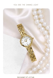 Elegant gold wheat leaf strap watch for women displayed on white silk with pearls