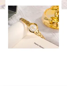 Dettaglio elegante orologio al quarzo dorato con indici in cristallo su quadrante bianco