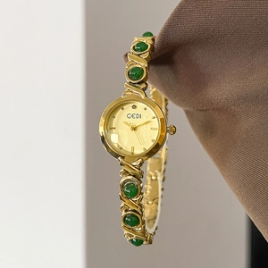 GEDI luxury gold watch with green bead bracelet strap shown in a hanging display
