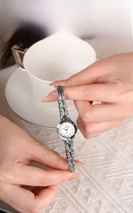 Dettaglio dell'orologio a catena argento con cristalli su uno sfondo accogliente ed elegante