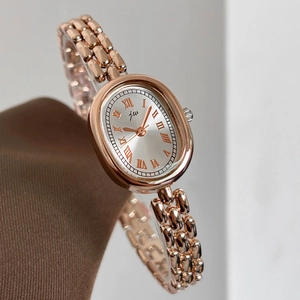 Close-up of elegant rose gold oval women's watch with Roman numerals on silk