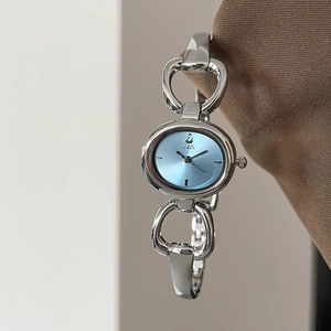 Women's oval silver bangle watch featuring a light blue sunray dial and chain link strap