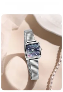 Détail d'une montre carrée argentée avec cadran en nacre et bracelet élastique
