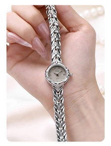 Close-up of elegant silver quartz watch with a unique wheat-ear pattern woven bracelet