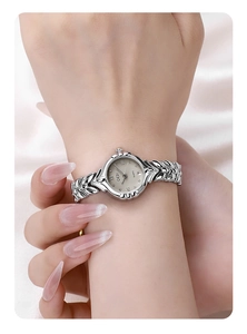 Close-up of GEDI vintage silver wheat-pattern watch strap on satin fabric background