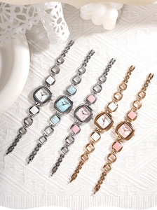 Detail of GEDI quartz bracelet watches with mother of pearl dials on white knit fabric