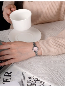 Donna elegante che indossa un orologio a bracciale argento con quadrante rosa al caffè