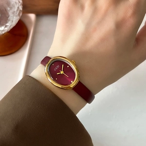 Vintage oval gold watch with burgundy leather strap on female wrist by GEDI