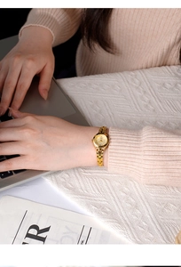 Dettaglio di un orologio a bracciale dorato vintage indossato da una modella al PC