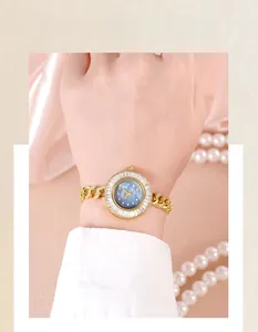 Close-up of luxury gold quartz watch with blue sunray dial and crystal bezel
