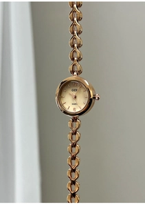 Makro-Detail einer roségoldenen Armbanduhr mit elegantem herzförmigem Gliederkettenband