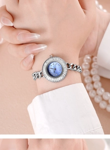 Close-up of silver chain watch with blue mother-of-pearl dial and zircon-set bezel