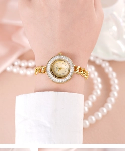 Detailed view of luxury gold chain watch with mother of pearl dial and zircon bezel